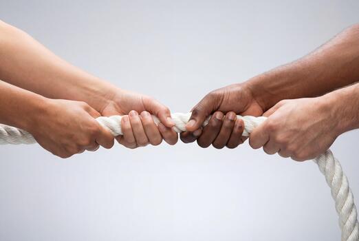diverse-hands-pulling-white-rope-together-in-tug-of-war-concept-against-grey-background-photo